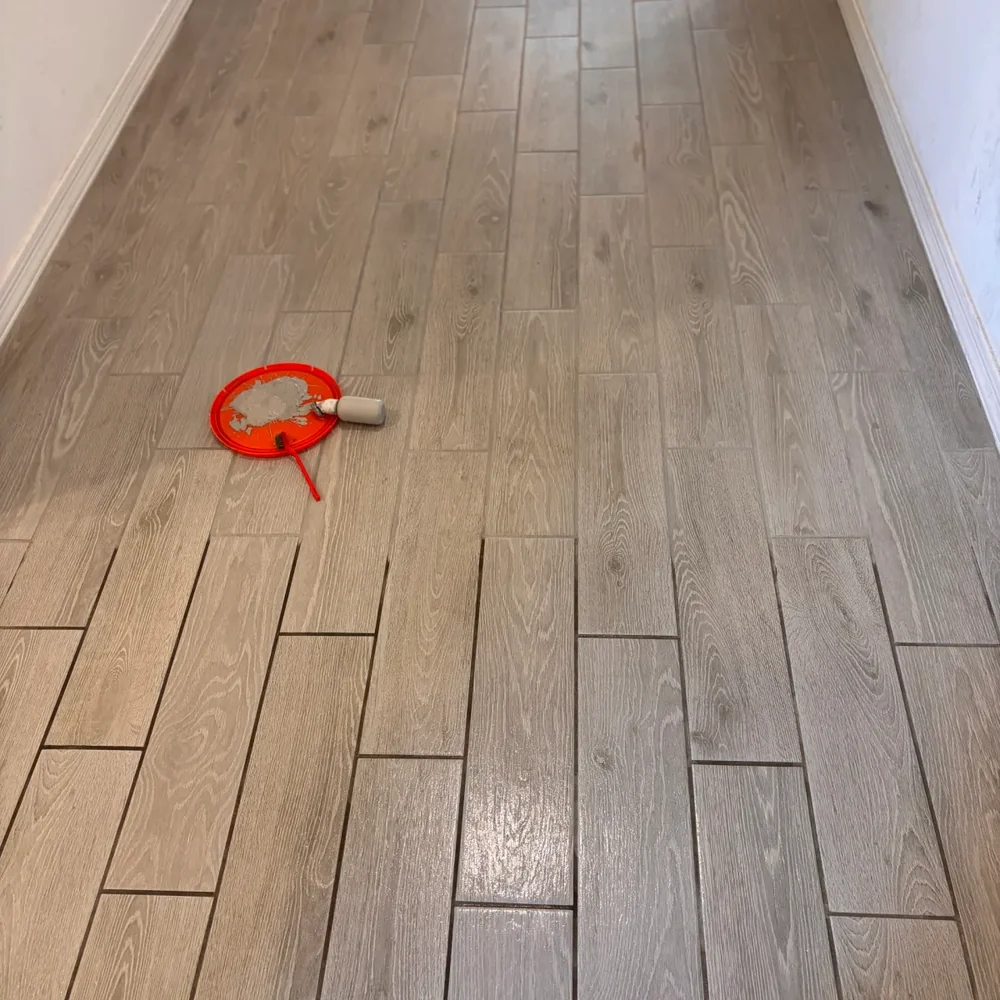 Wood-look tile floor after grout color sealing with the applicator roller