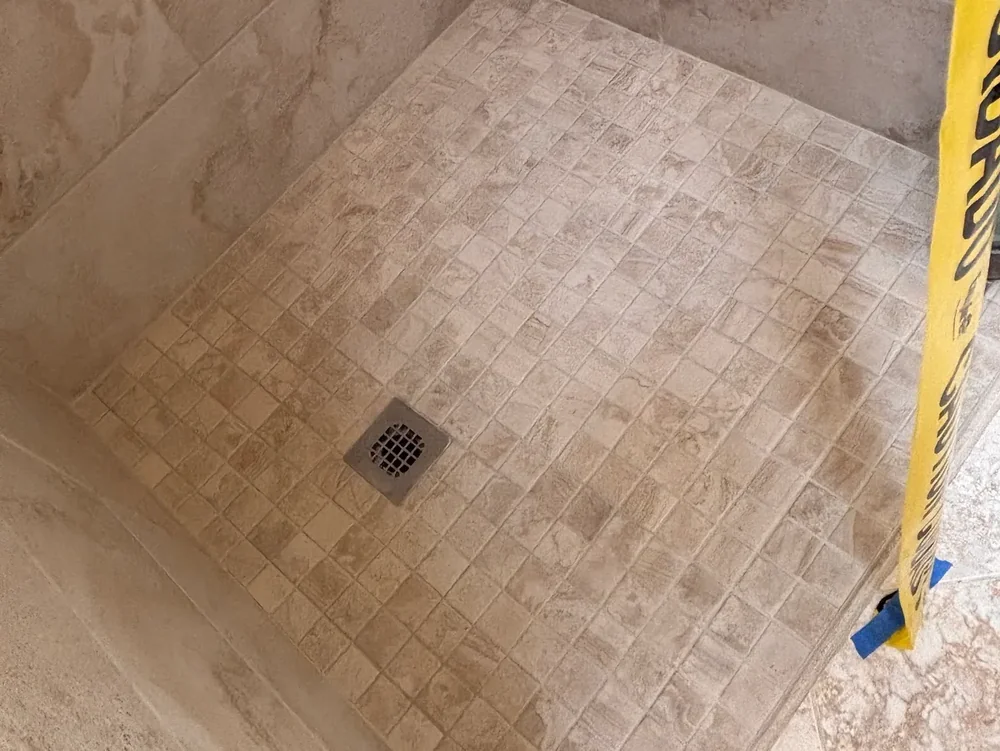 Shower pan with small mosaic tile after cleaning